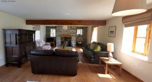 Cosy lounge with a woodburner, stone-wall and 6 photo windows